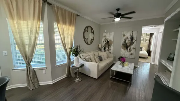 a living room with furniture a mirror and a large window