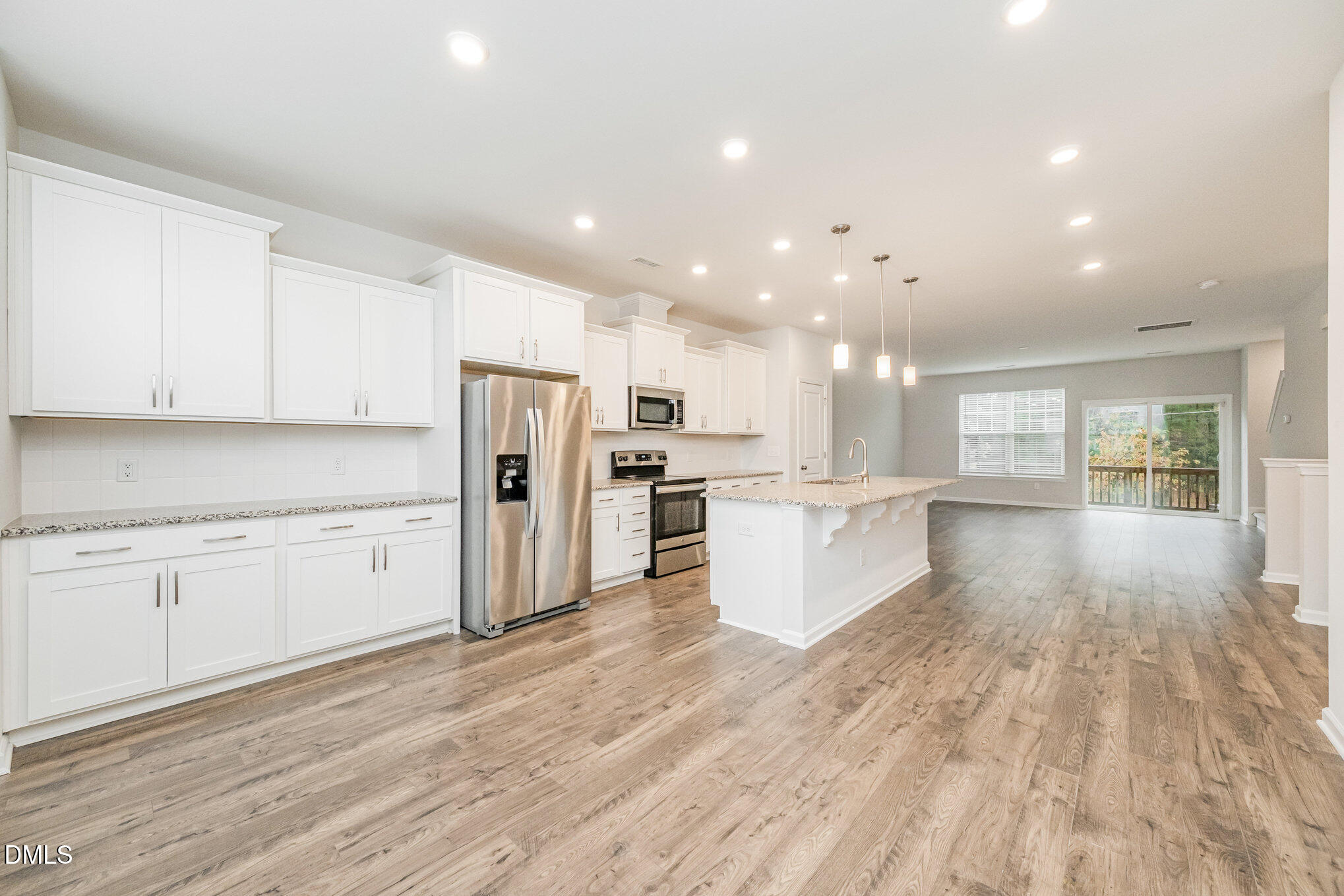 1019 Islip Place Durham, NC 27703 - Photo 4 of 18 a large kitchen with cabinets wooden floor stainless steel appliances and a window