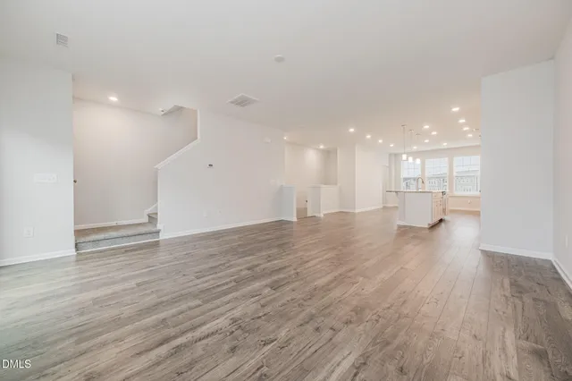 a view of an empty room and a kitchen
