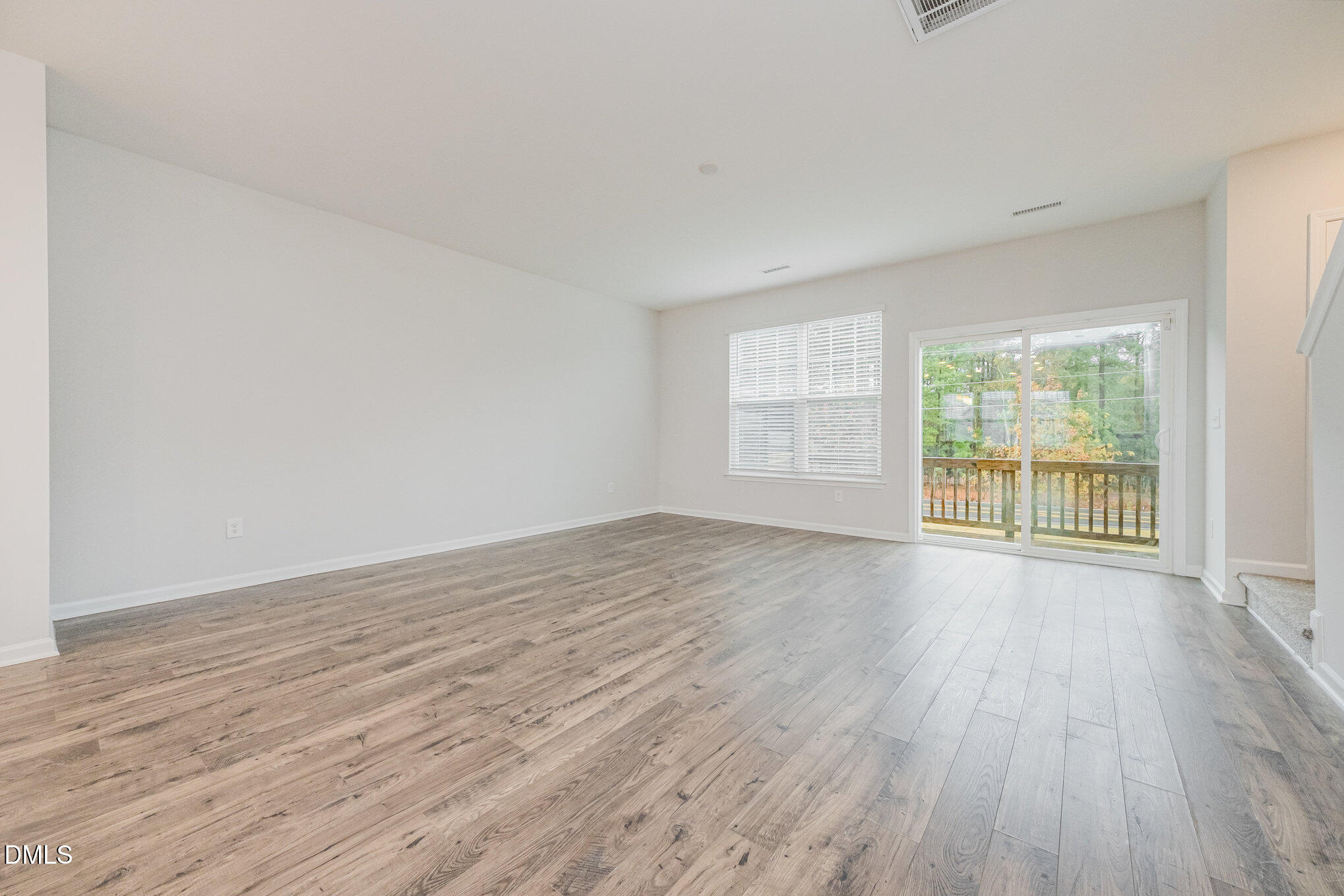 1019 Islip Place Durham, NC 27703 - Photo 6 of 18 a view of an empty room with wooden floor and a window