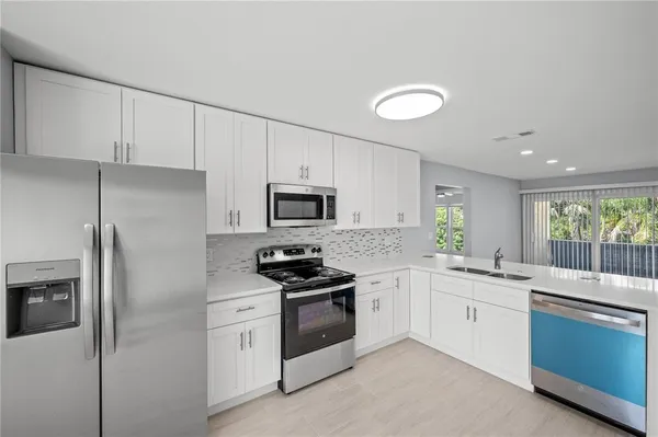 a kitchen with stainless steel appliances a sink stove and refrigerator