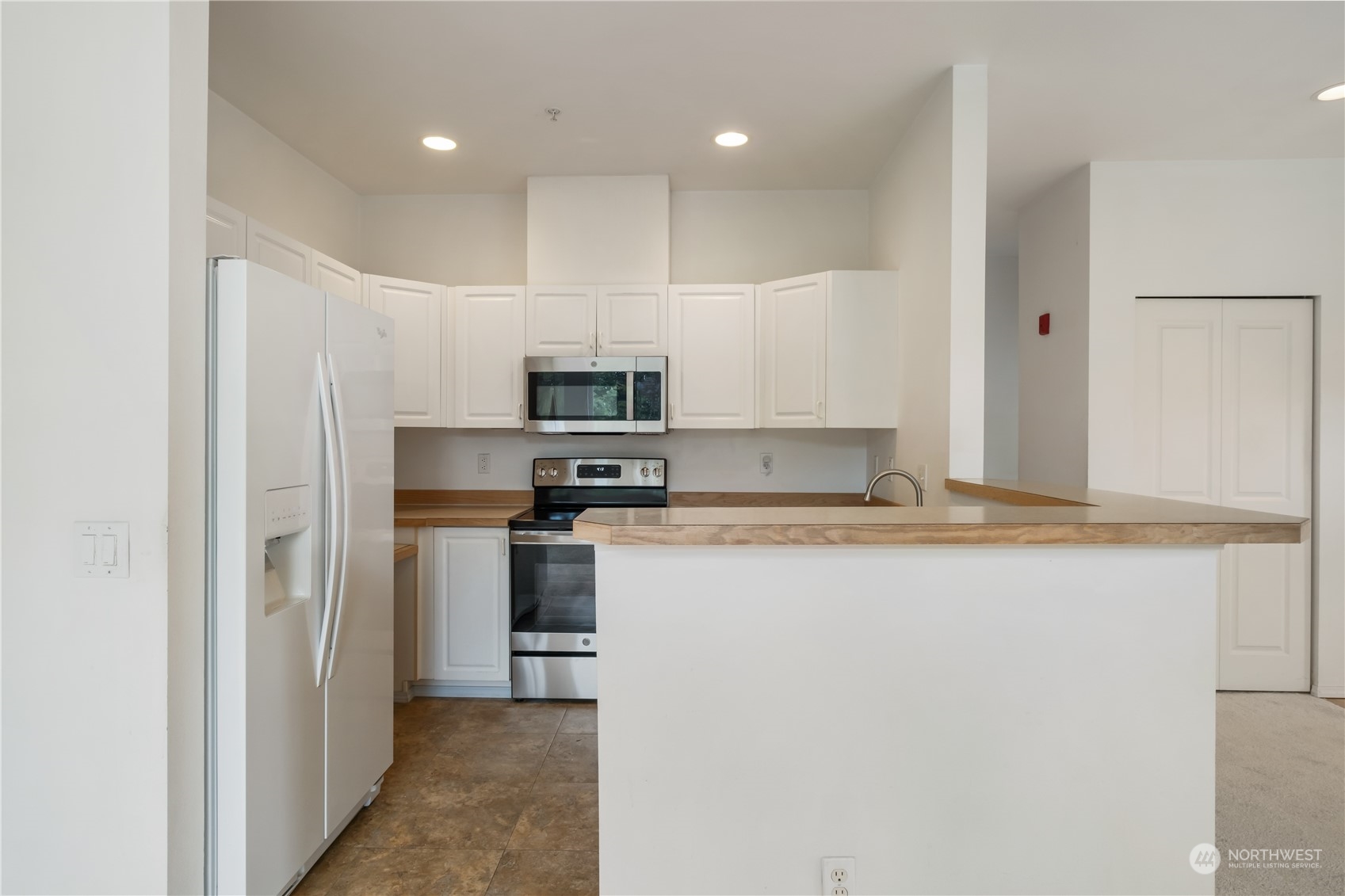 2300 Benson Road South, Unit H1 Renton, WA 98055 - Photo 10 of 27 a kitchen with kitchen island a sink stainless steel appliances and white cabinets
