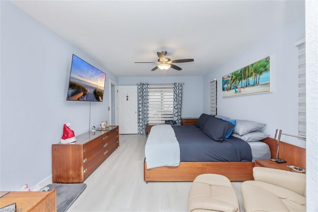 4228 31st Place Southwest Naples, FL 34116 - Photo 15 of 28 a bedroom with furniture and a chandelier