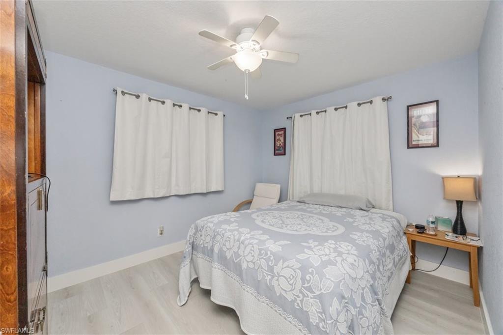 4228 31st Place Southwest Naples, FL 34116 - Photo 20 of 28 a bedroom with a bed and a chandelier