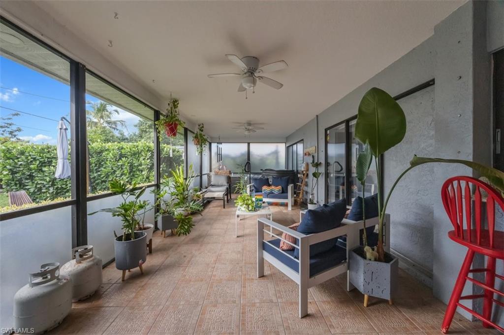 4228 31st Place Southwest Naples, FL 34116 - Photo 23 of 28 a living room with furniture a floor to ceiling window and a potted plant