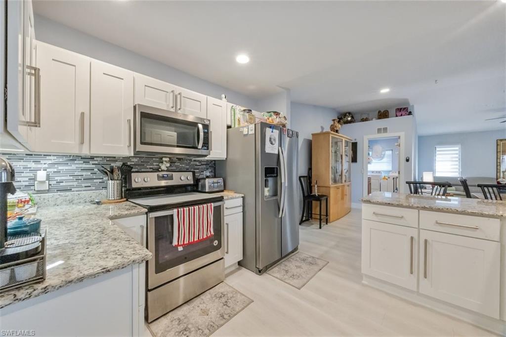 4228 31st Place Southwest Naples, FL 34116 - Photo 6 of 28 a kitchen with stainless steel appliances granite countertop a refrigerator and a stove top oven