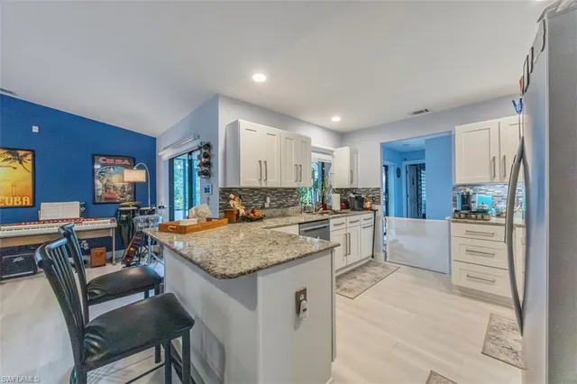 a kitchen with granite countertop white cabinets and white appliances
