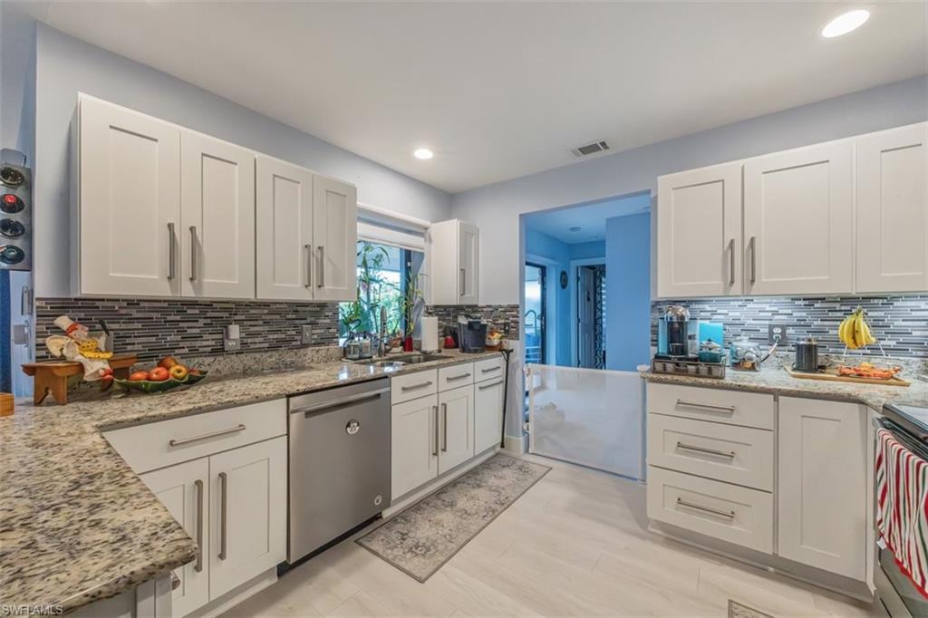 4228 31st Place Southwest Naples, FL 34116 - Photo 9 of 28 a kitchen with granite countertop white cabinets and white appliances