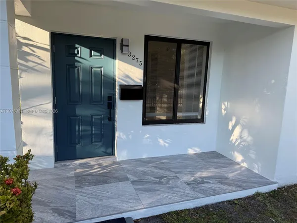 a view of a hallway with wooden floor and a potted plant