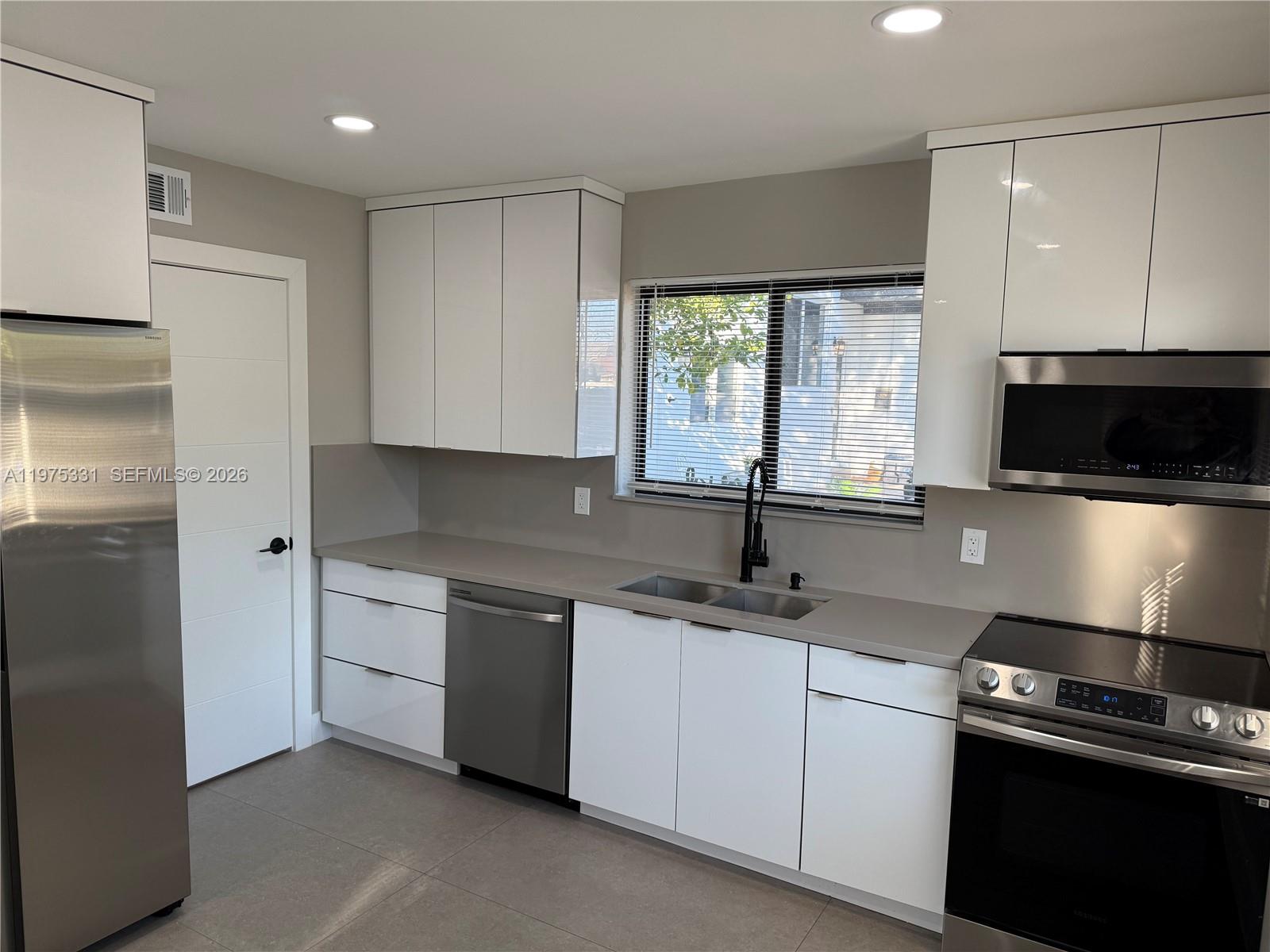 3275 Southwest 27th Street, Unit 3275 Miami, FL 33133 - Photo 4 of 17 a kitchen with a sink stove and microwave