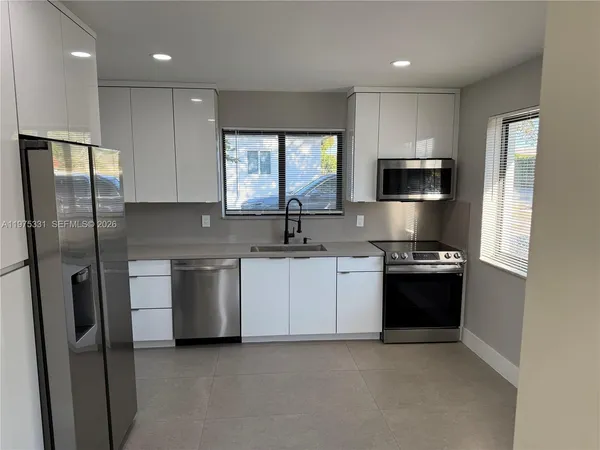 a kitchen with stainless steel appliances granite countertop a refrigerator sink and stove