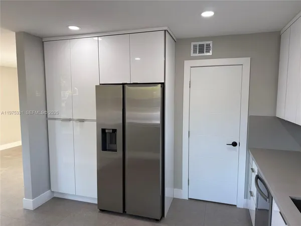 a metallic refrigerator freezer sitting in a kitchen