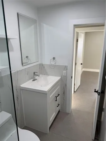 a bathroom with a sink a toilet and a mirror