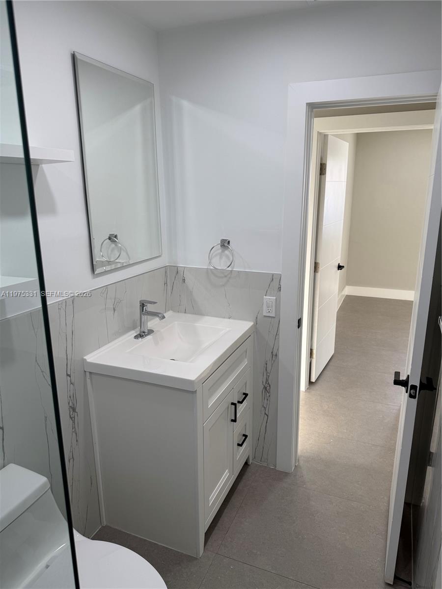 3275 Southwest 27th Street, Unit 3275 Miami, FL 33133 - Photo 8 of 17 a bathroom with a sink a toilet and a mirror