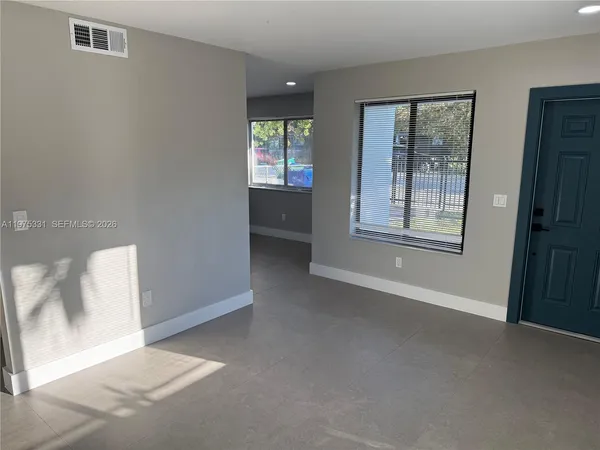 an empty room with windows and closet