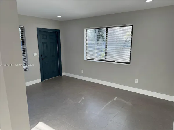 an empty room with windows and closet