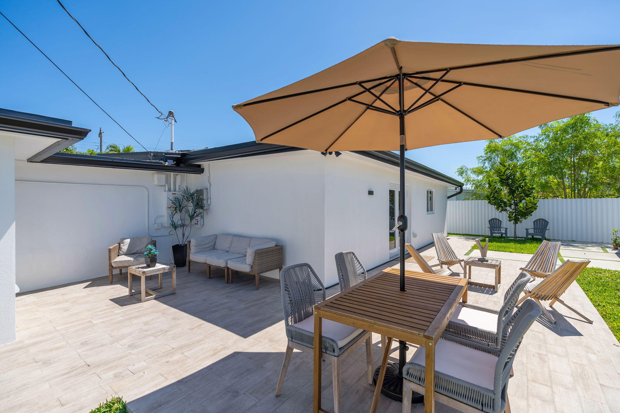 11290 Southwest 48th Street Miami, FL 33165 - Photo 36 of 53 a patio with a table and chairs under an umbrella