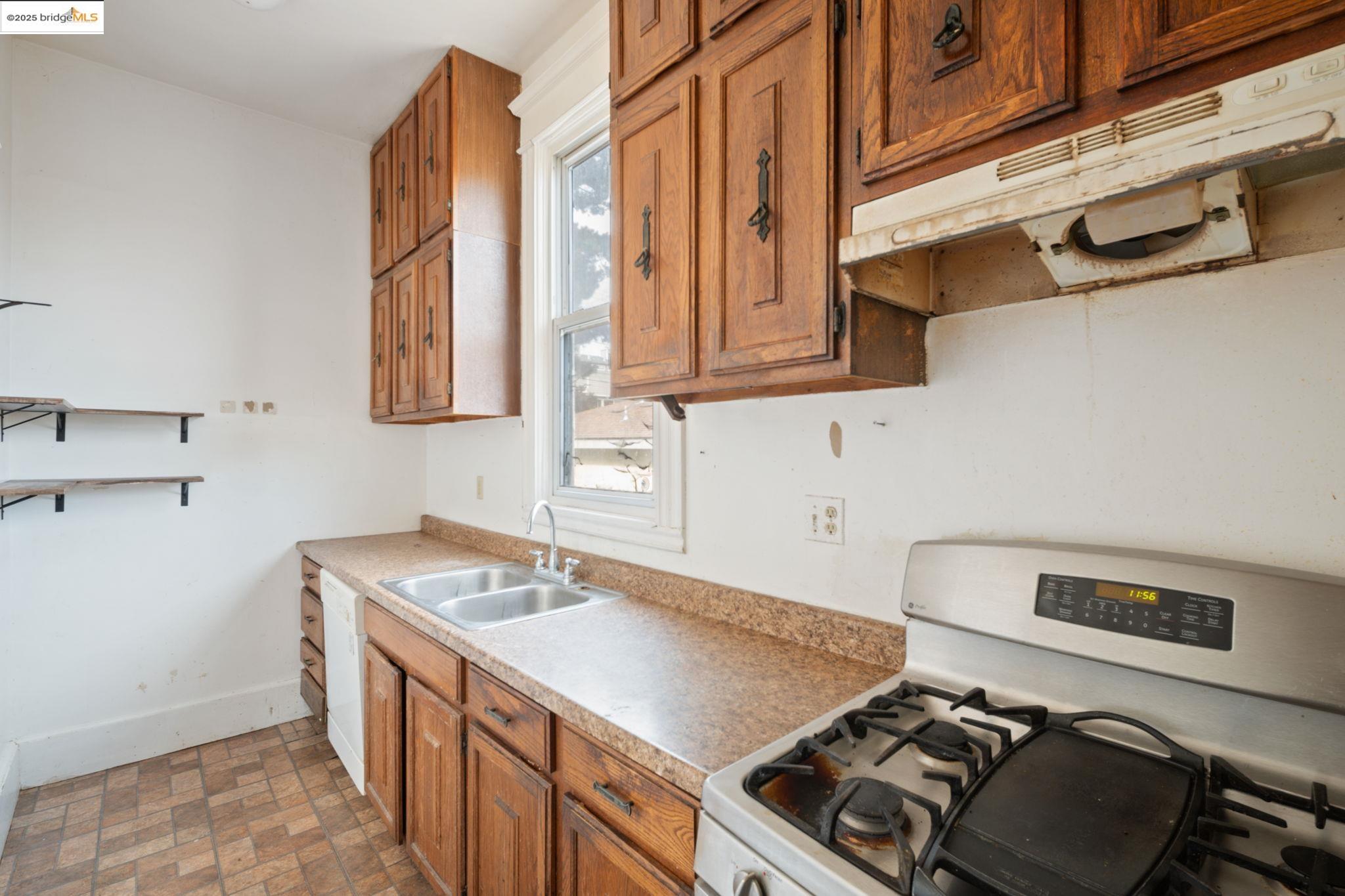 443 Watson Street Monterey, CA 93940 - Photo 15 of 51 Kitchen featuring brown cabinetry, white appliances, under cabinet range hood, and light countertops
