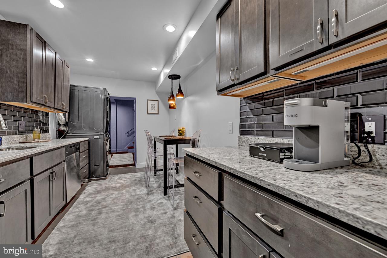 1709 Bank Street Baltimore, MD 21231 - Photo 35 of 49 a kitchen with granite countertop stainless steel appliances a sink counter space cabinets and wooden floor