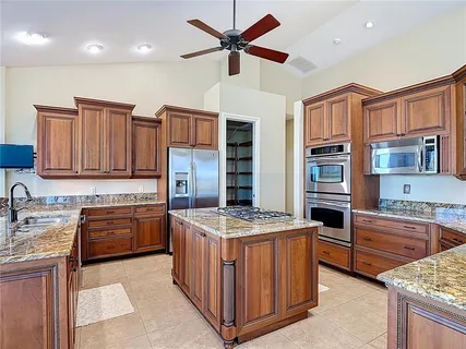 a bedroom with a bed a couch and a chandelier