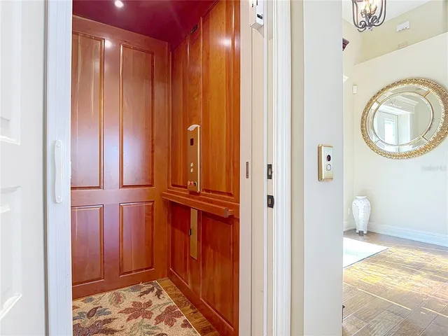 a bedroom with a large bed and a chandelier