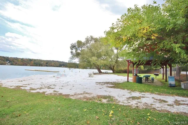 a backyard of a house with large trees and outdoor seating