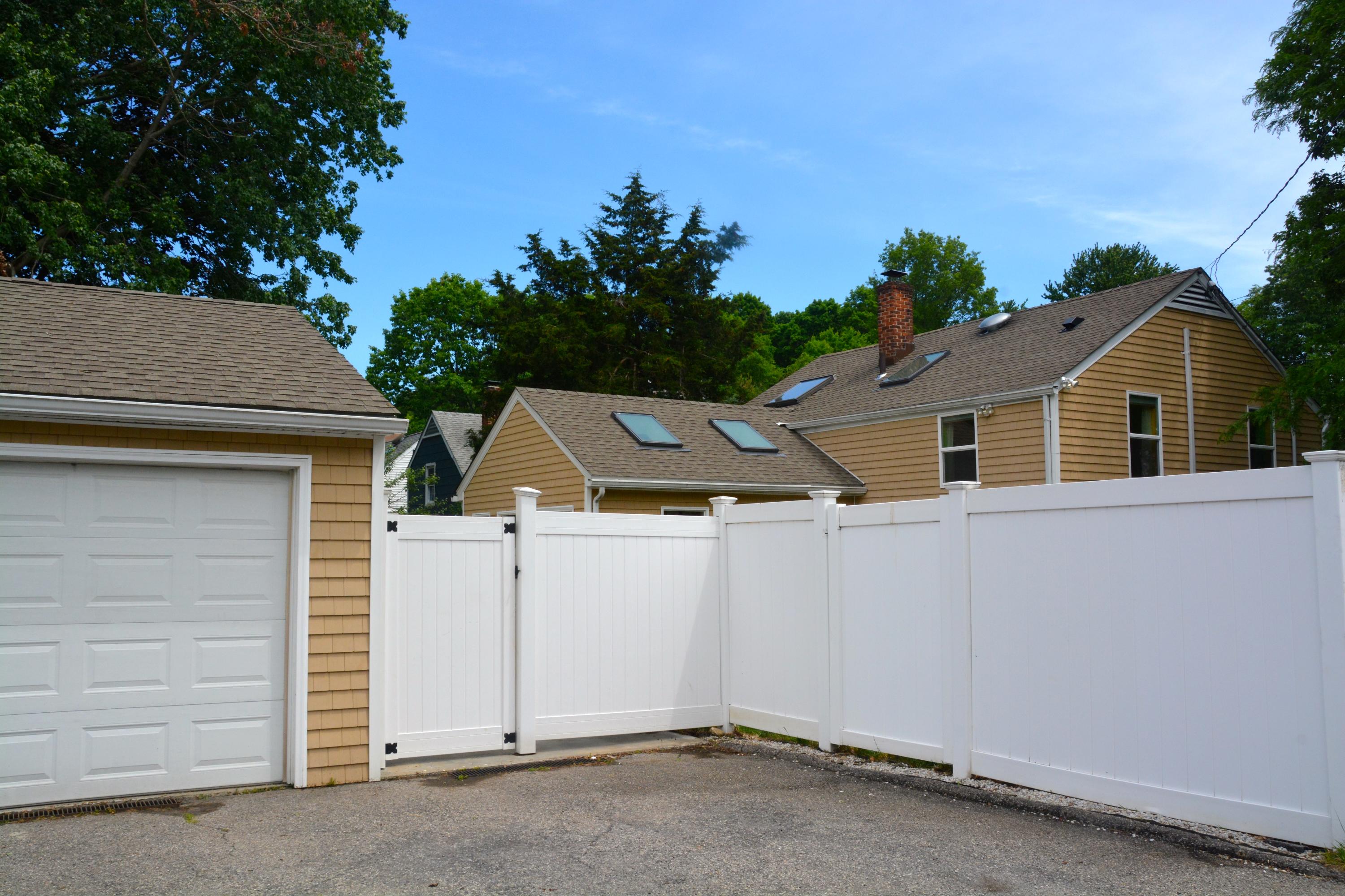 165 Hollow Tree Ridge Road Darien, CT 06820 - Photo 36 of 37 a view of a white house with a yard and garage