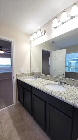 a bathroom with a granite countertop sink and a mirror