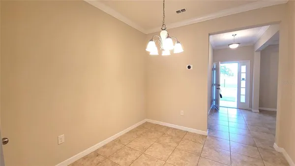 a view of a hallway with wooden floor and a chandelier