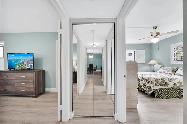 a view of a bedroom with bed and mirror
