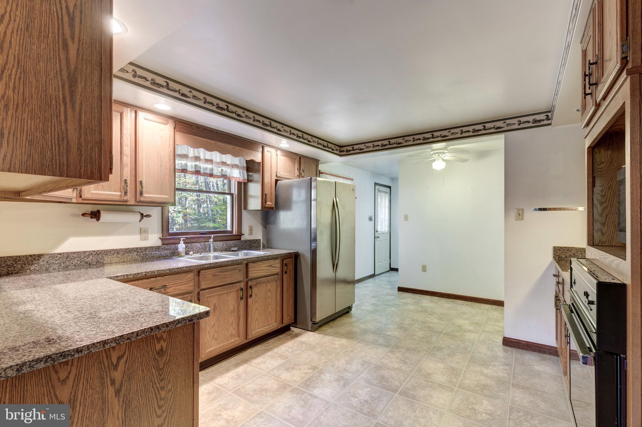 3870 Roop Road New Windsor, MD 21776 - Photo 5 of 59 a kitchen with stainless steel appliances granite countertop a sink stove and refrigerator