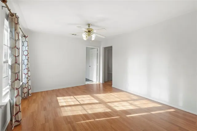a view of a big room with windows and chandelier fan