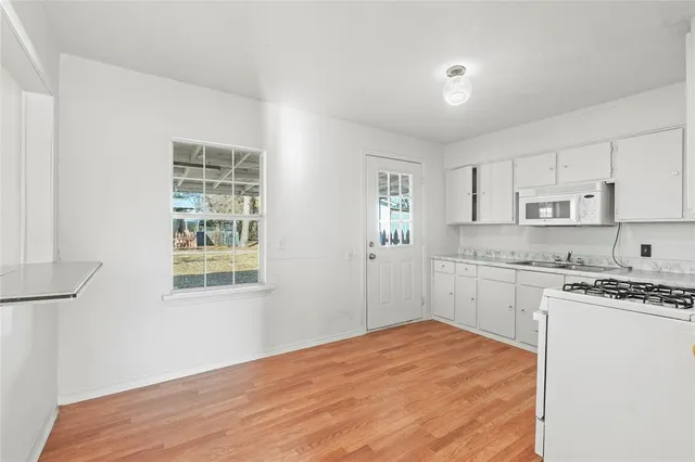 a kitchen with stainless steel appliances granite countertop a stove a sink and white cabinets