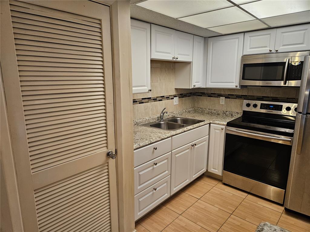 946 Virginia Street, Unit 104 Dunedin, FL 34698 - Photo 13 of 23 a kitchen with a stove and a microwave