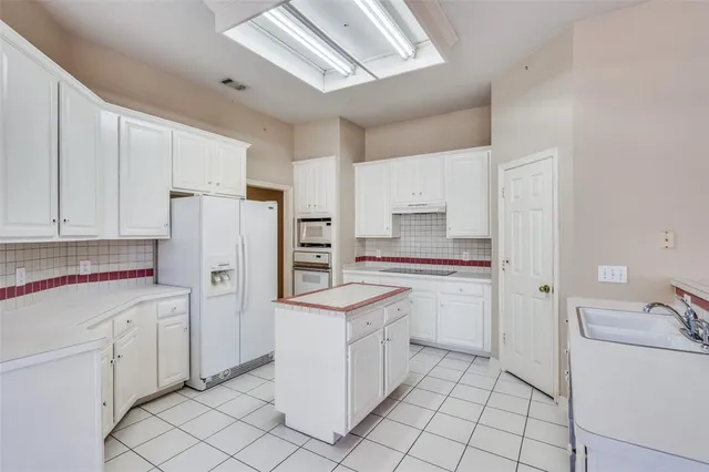 a kitchen with white cabinets and white appliances