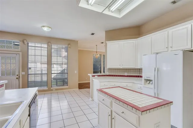 a kitchen with a refrigerator a stove a sink and a cabinets