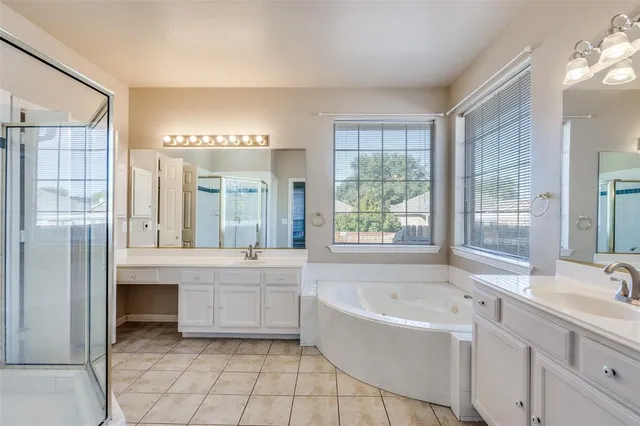 a bathroom with a tub a sink and a large mirror