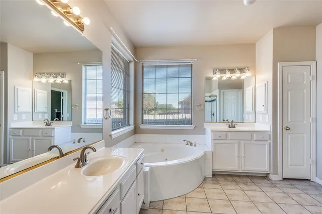 a bathroom with a tub sink and mirror