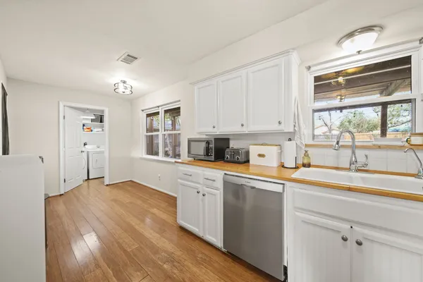 a kitchen with stainless steel appliances granite countertop a sink a stove and cabinets