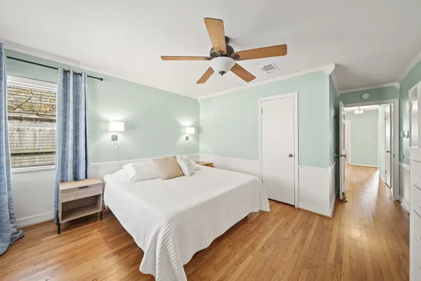 a bedroom with a bed and wooden floor