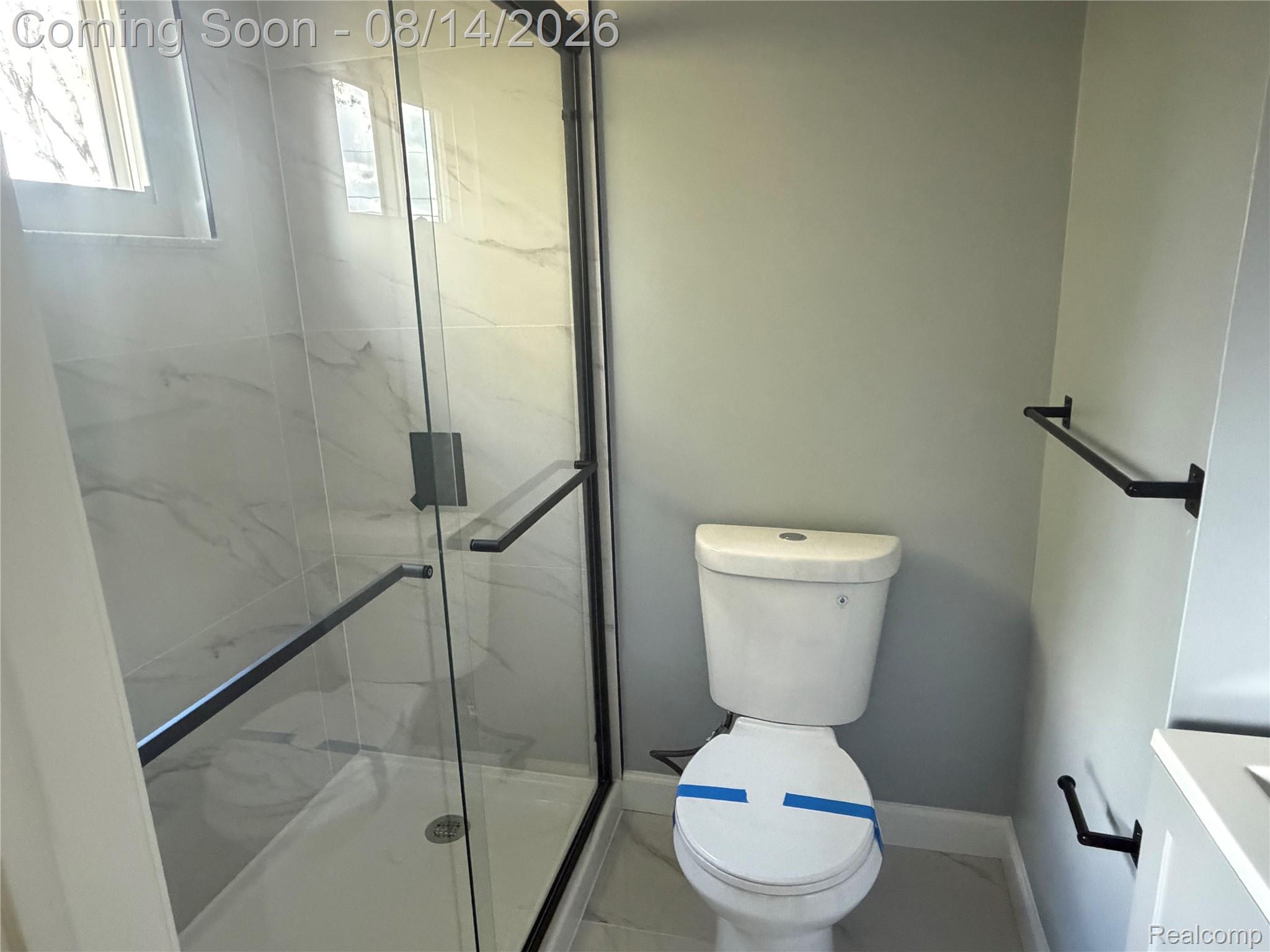 20698 Coachwood Road Riverview, MI 48193 - Photo 26 of 37 Glass-enclosed shower featuring white marble-look tile surround and matte black hardware