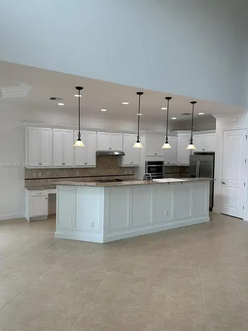 a large kitchen with stainless steel appliances kitchen island a large counter top and a sink