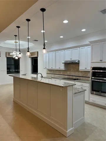 a kitchen with stainless steel appliances granite countertop a sink a stove and a refrigerator