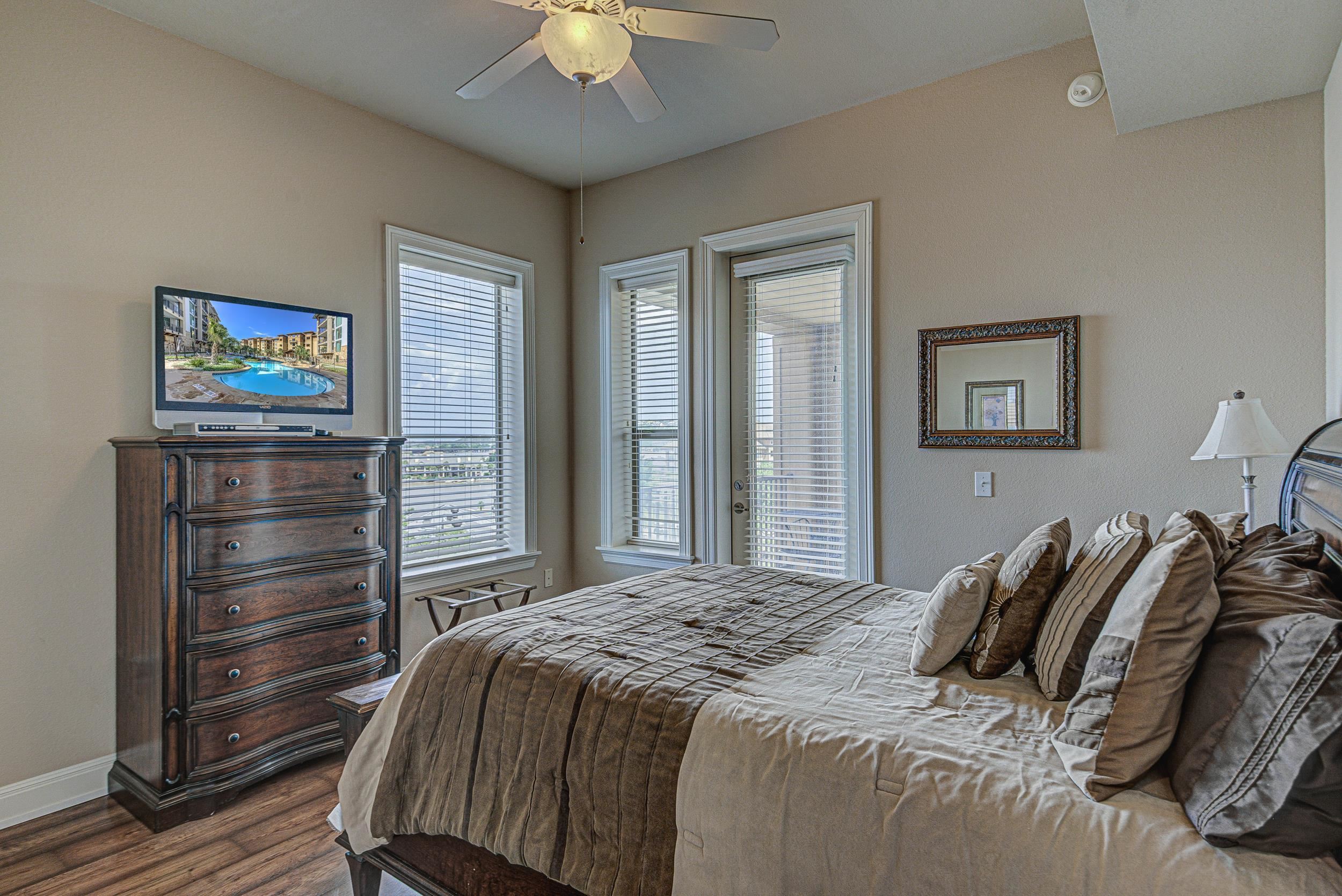 101 West Bank, Unit 51 Horseshoe Bay, TX 78657 - Photo 11 of 30 a bedroom with a bed and a chandelier