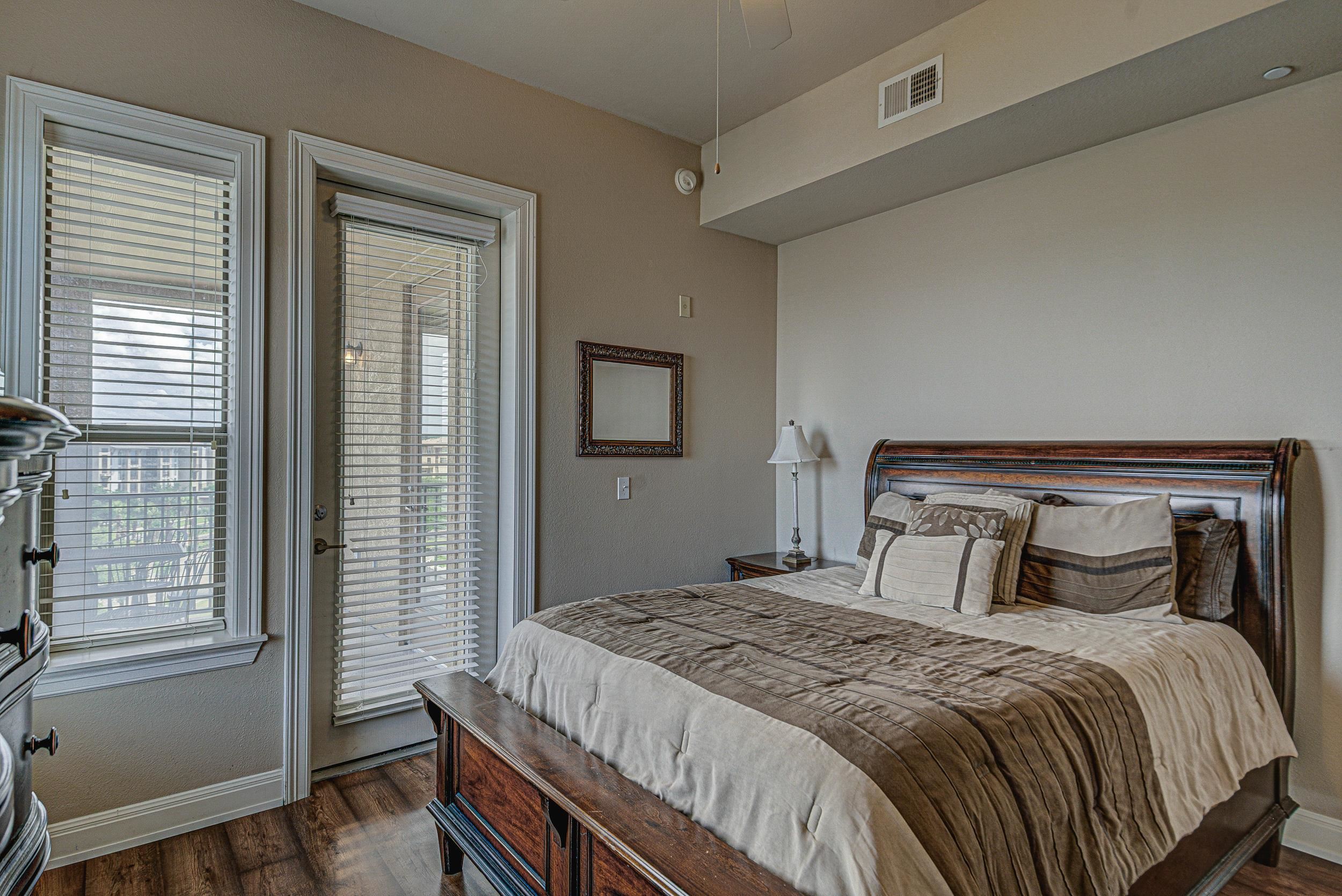 101 West Bank, Unit 51 Horseshoe Bay, TX 78657 - Photo 12 of 30 a bedroom with a bed and wooden floor