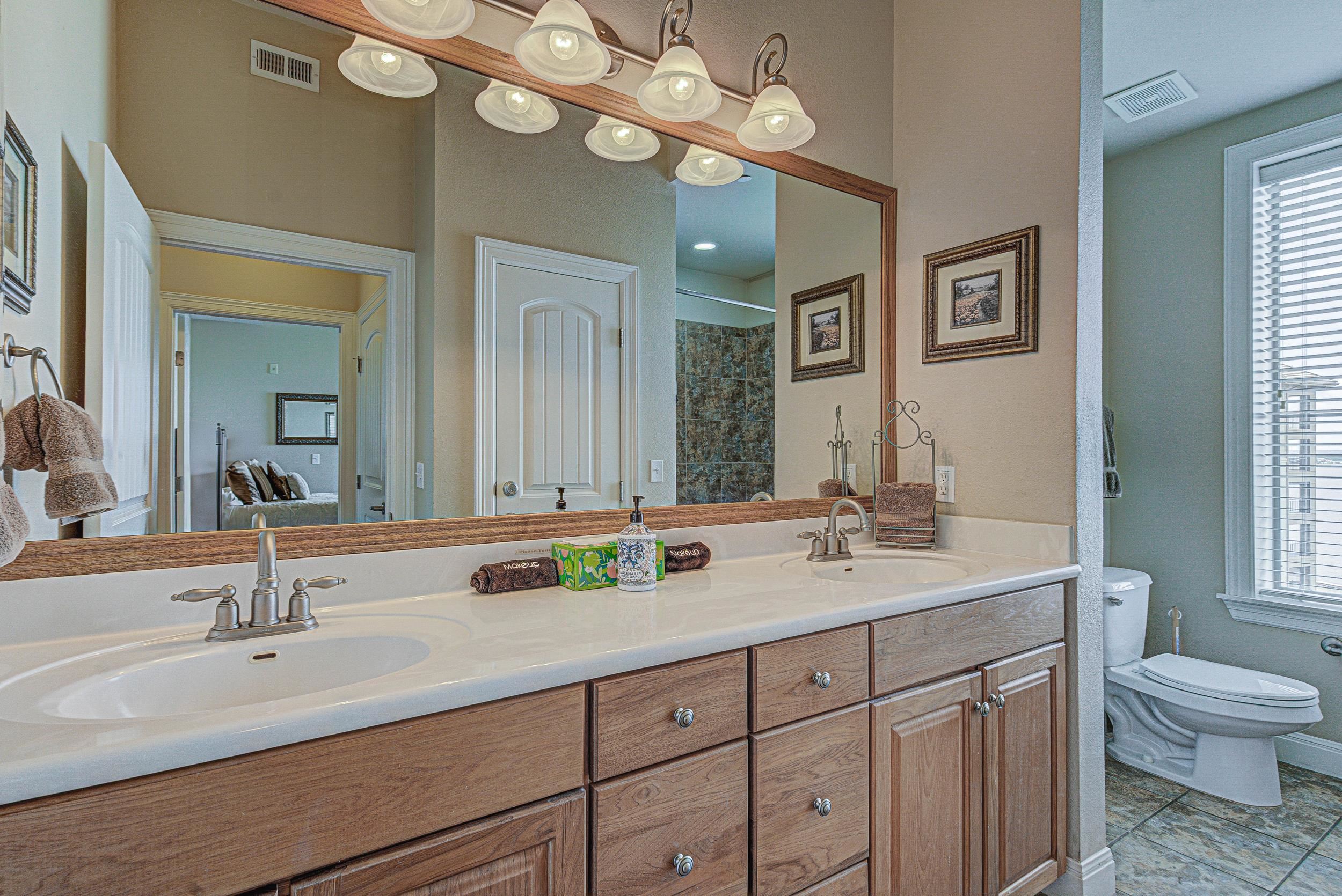 101 West Bank, Unit 51 Horseshoe Bay, TX 78657 - Photo 13 of 30 a bathroom with a granite countertop double vanity sink mirror and toilet