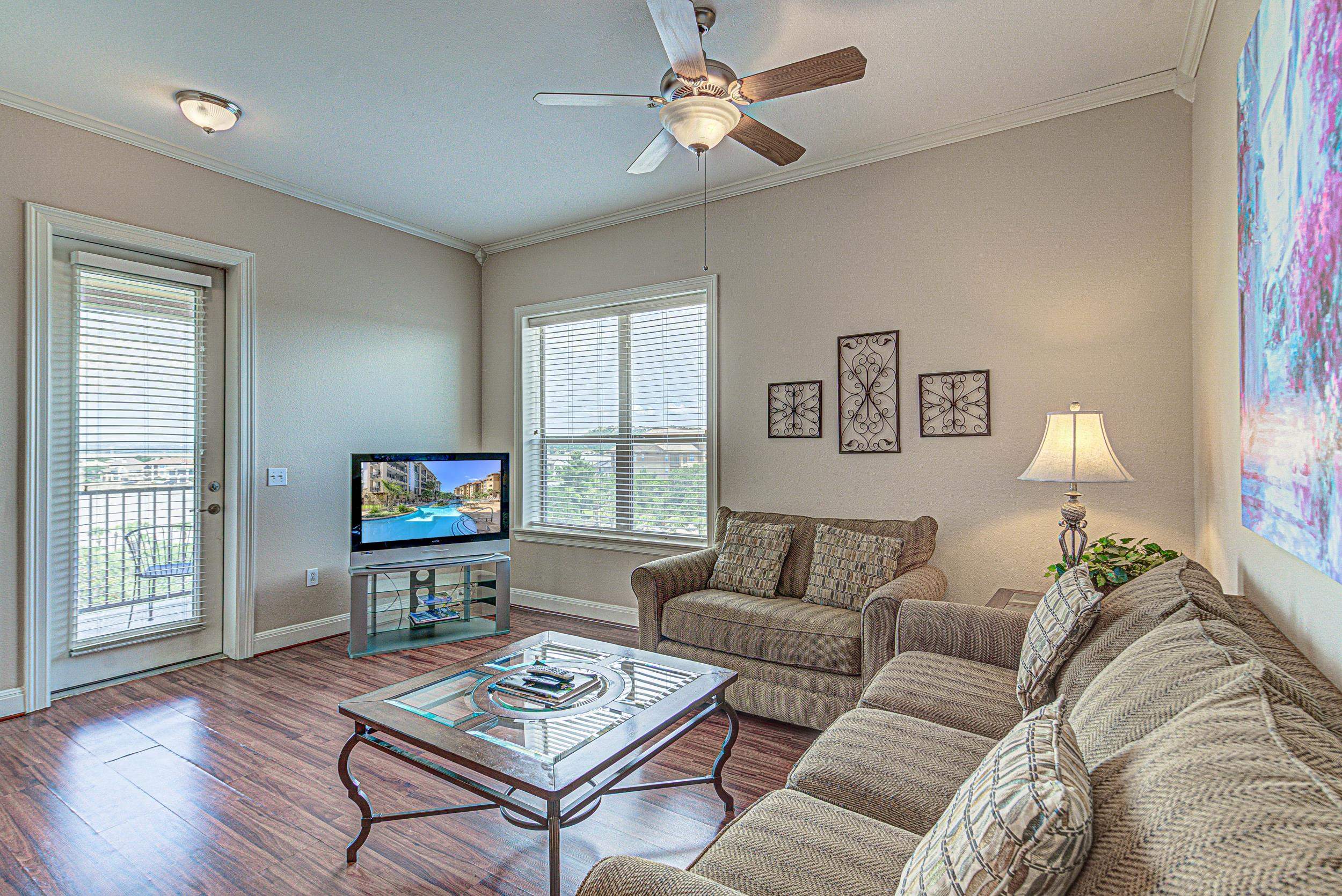 101 West Bank, Unit 51 Horseshoe Bay, TX 78657 - Photo 4 of 30 a living room with furniture a flat screen tv and a window