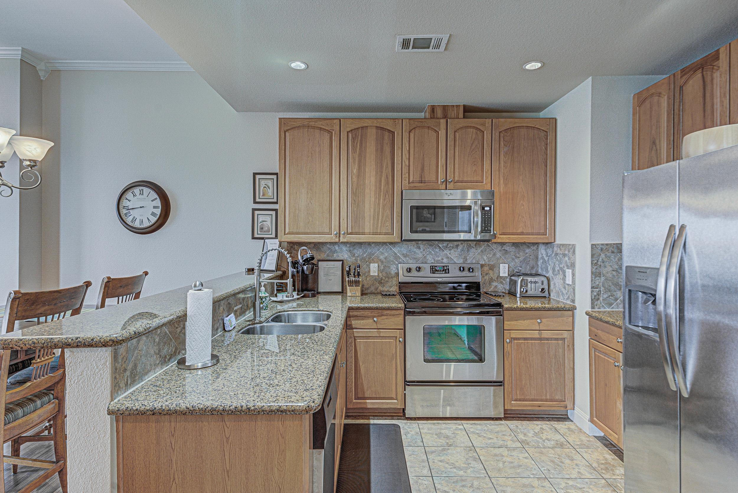 101 West Bank, Unit 51 Horseshoe Bay, TX 78657 - Photo 9 of 30 a kitchen with stainless steel appliances granite countertop a stove top oven a sink and dishwasher