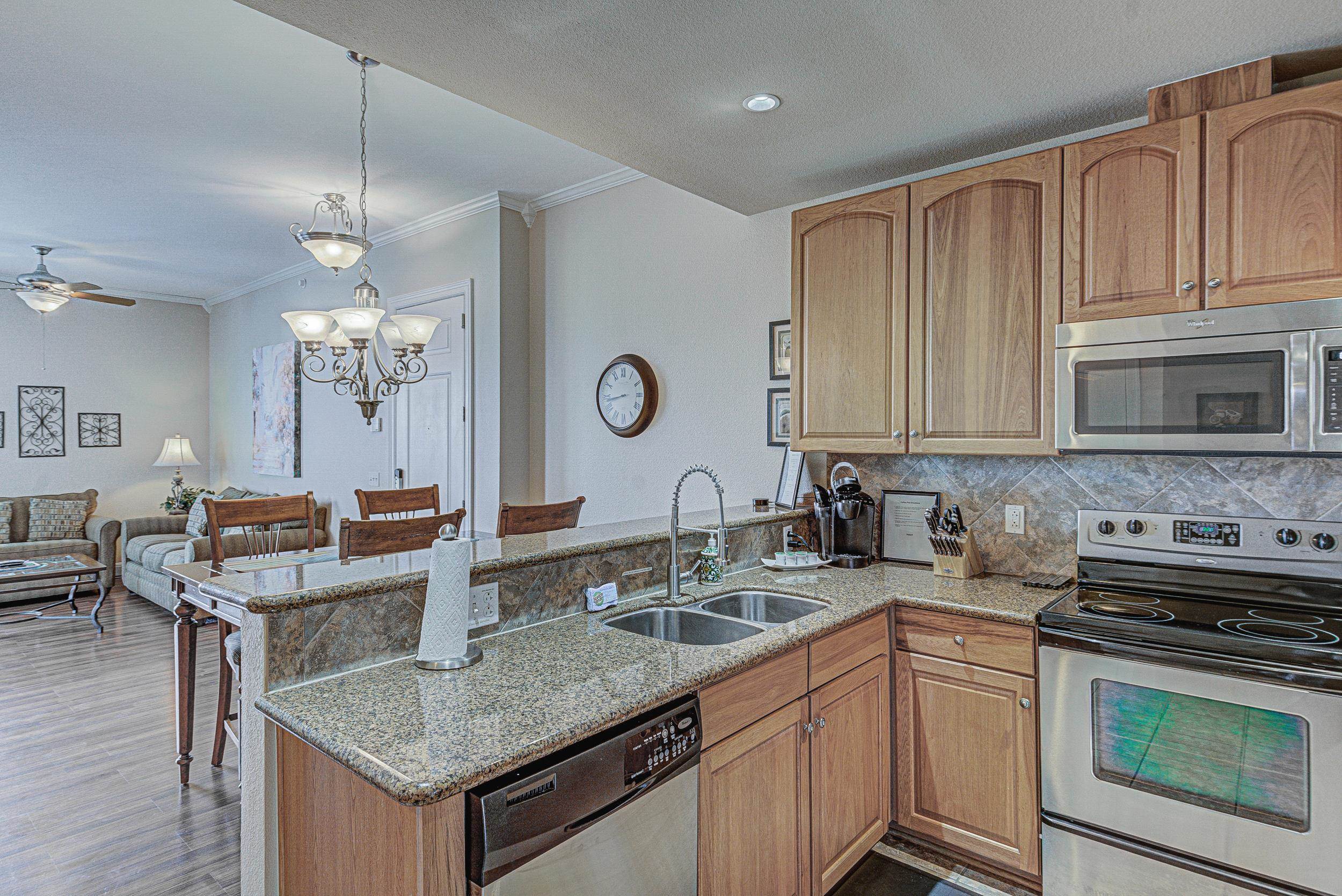 101 West Bank, Unit 51 Horseshoe Bay, TX 78657 - Photo 10 of 30 a kitchen with granite countertop a sink cabinets and stainless steel appliances