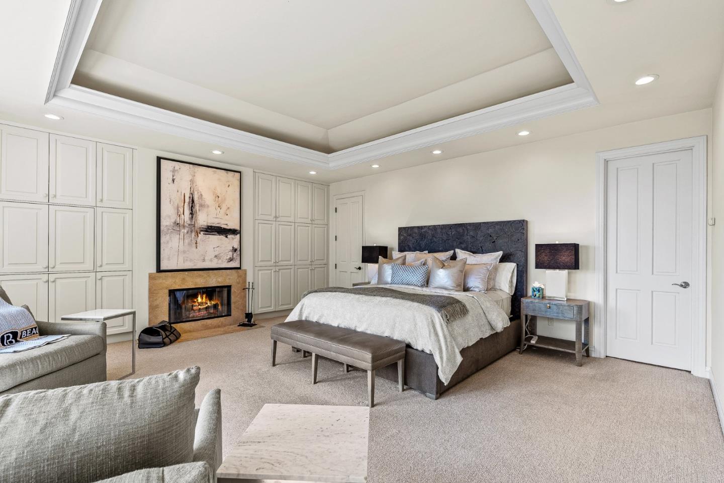 4038 Sunridge Road Pebble Beach, CA 93953 - Photo 20 of 48 a spacious bedroom with a bed a fireplace and a couch
